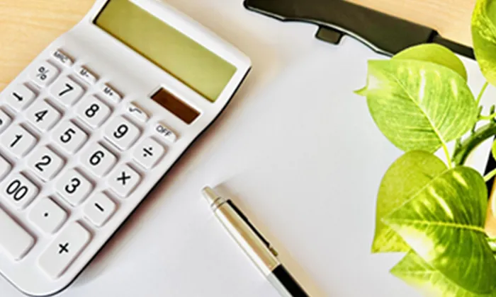 電卓とペン、書類、観葉植物。プランとお見積もりを提示する様子