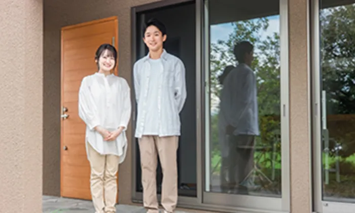 新しい家の玄関で笑顔の若い夫婦